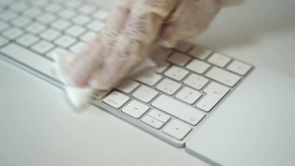 Osoby ręka w białej rękawicy ochronnej medycznej za pomocą mokrej chusteczki i czyszczenia ostrożnie klawiatury laptopa w miejscu pracy. Środki zapobiegawcze w okresie epidemii koronawirusów, dezynfekcja przedmiotów — Wideo stockowe