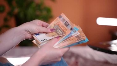 Kadın beyaz zarf açıyor ve 20-50 avro banknot sayıyor. Büyük iş gelirleri, finansal kariyerde başarı. Banka döviz işlemleri için kağıt para, nakit para hesapları, para