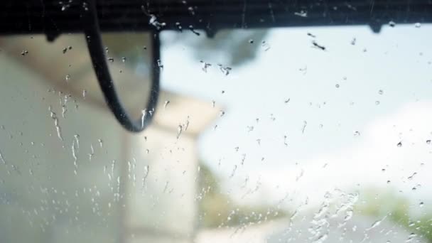 Coche pasando por el túnel de lavado, gotas de agua cayendo en el parabrisas, lavadora automática de coches. Secado exterior del coche después de la limpieza total en servicio automático — Vídeos de Stock