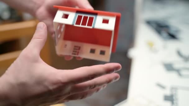 Man ingenieur met behulp van plastic en papier ontwerper items voor de bouw van metselaar model, eigendom mockup voor klanten. Onroerend goed bouwproject, woonhuis in miniatuur. Ingenieur en — Stockvideo