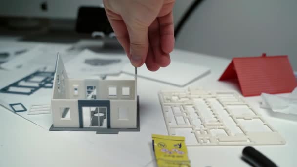 Sviluppare il progetto di costruzione della casa vivente, ingegnere creando casa in miniatura con plastica colorata, fondazione incollaggio esperto con cornici e pareti di costruzione. Piano di costruzione esclusivo per — Video Stock