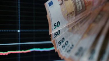 Çizelgelerde avroluk kağıt para birimi, 50 avro para tutan tüccar. Analiz ve veri istatistikleri, borsa çöküşü. Mal varlığı ve hisse kaybı, enflasyon konsepti ve finansal kriz