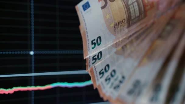 Euro Papierwährung auf Diagrammen Hintergrund, Händler hält 50 Euro Währung. Analyse und Datenstatistik, Börsencrash. Verlust von Vermögenswerten und Aktien, Konzept der Inflation und Finanzkrise in der — Stockvideo