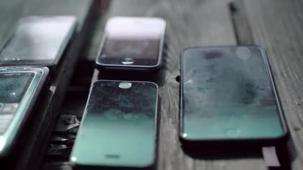 ROME, ITALIE - 6 MAI 2020 : Des téléphones portables modernes et obsolètes couchés sur la table, d'excellentes collections de téléphones portables de différentes époques et âges. Téléphones cellulaires à clavier à l'ancienne, électronique — Video