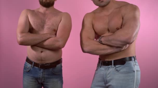 Homem gordo e musculoso em comparação com fundo rosa. Homem gordo imitando poses de desportista, corpos antes e depois do treinamento, treino e controle correto de calorias. Problema de excesso de peso e — Vídeo de Stock