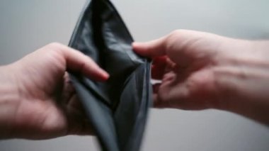 Siyah deri cüzdan taşıyan, beyaz arka planda açılan, boş cüzdan ve parasız biri. Küresel mali kriz ve toplam işsizlik, iflas ve borç, insanların depresyona girmesi