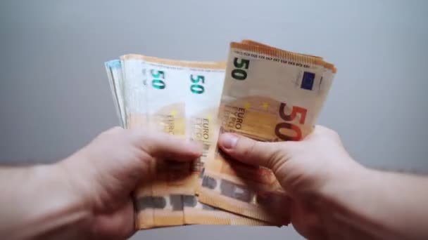 Homem feliz segurando um pacote de notas de euro e contando dinheiro, pessoa ganhou prêmio de loteria no cassino, jovem milionário calculando seu prêmio em dinheiro. Conceito de finanças e sucesso — Vídeo de Stock