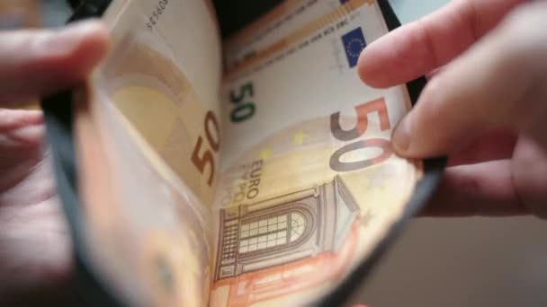 Zakenman die eurobankbiljetten telt uit zwart lederen portemonnee, geld bespaart voor hypotheekbetaling en uitgaven. Geldkosten en financiële crisis, valuta en werkloosheid — Stockvideo