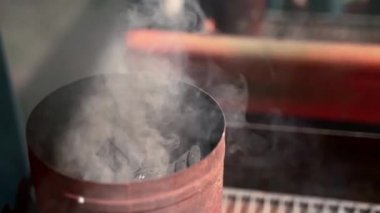 Izgaradan önce uzun oval metal tavada kömür yakmak, dumanın yavaş çekimde dağılması. bbq ızgarasında daha iyi et kızartması için kömür ısıtma işlemi. Barbekü ızgarası için hazırlık