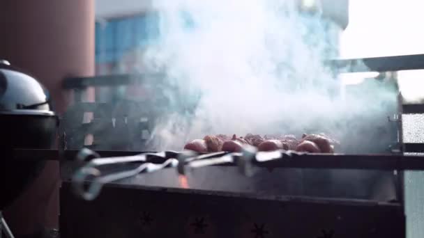 Braseiro de churrasco com carvão queimado no terraço, assando espetos de carne em chamas e fumaça. Comida de preparação para festa ao ar livre, conceito de churrasco — Vídeo de Stock