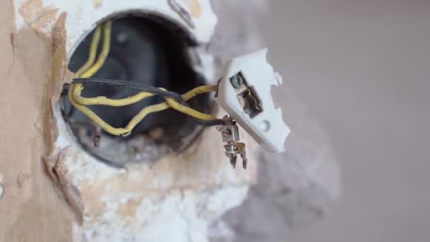 壁、ワイヤー断熱材と安全性の中にオープンソケットで黒と黄色のツイスト線のクローズアップ。優れた電気サービスと短絡防止 — ストック動画