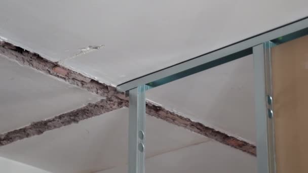 Metallkonstruktionsprofile, die an der Deckenwand auf der Baustelle montiert werden, Prozess der Wiederherstellung der Wohnung mit Trockenbau. Installation von Metallplatten für die Erweiterung des Hausprojekts. Gips — Stockvideo