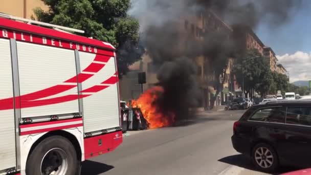 ROME, ITALIEN - JUNI 11, 2020: Nödbrandbil anländer på den centrala gatan i Rom, räddningsteam blockerar vägtrafiken och försöker släcka brand och stigande svart rök nära bostäder — Stockvideo