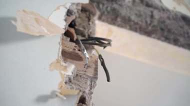 Apartman duvarından sarkan aşağılayıcı bantlarla sarmalanmış kablolar yüksek voltajlı kabloların kısa devre riski var. Kötü elektrik hizmeti işi, tehlikeli kablolar ve güvensizlik kavramı