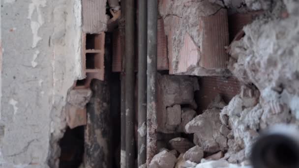 Instalación de tuberías de cobre dentro de la pared de hormigón en el sitio de construcción. Muro de ladrillo de edificio viejo agrietado y dañado con tubos oxidados sin funcionar. Trabajos de reparación con tuberías de agua o gas en el — Vídeos de Stock