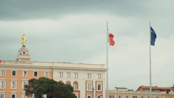 ŘÍM, ITÁLIE - 3. června 2020: Vlajky Evropské unie a Itálie vlály na nádraží Roma Termini na pozadí starobylých historických budov, slavného autobusového, vlakového a letištního nádražív hlavním městě — Stock video