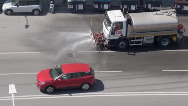 ΡΩΜΗ, ΙΤΑΛΙΑ - 3 ΙΟΥΛΙΟΥ 2020: Μηχανή καθαρισμού οδών οδηγείται αργά και ψεκάζει νερό με απολυμαντικό υπό πίεση. Φορτηγό σάρωσης που περνάει στους δρόμους και το καθαρίζει με νερό. — Αρχείο Βίντεο