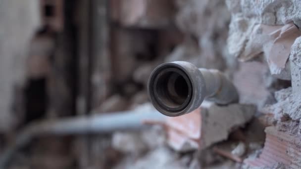 Long tuyau de cuivre rouillé à l'intérieur du mur de béton dans une vieille maison abandonnée, mur de briques détruit et tubes dans la construction du bâtiment. Système d'alimentation en eau ou gazoduc, travaux de réparation sur la construction — Video