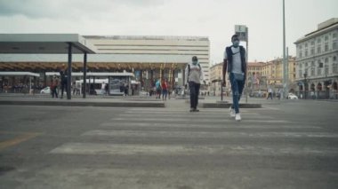ROMA, İtalya - 3 Temmuz 2020: Coronavirus salgını sırasında kalabalık Roman Termini İstasyonu, koruyucu maske takan ve cadde boyunca yürüyen yolcular. İnsanlar otobüs durağında bekliyor ve kitap okuyorlar.
