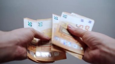 Avro banknotlarını sayıyorum, kağıt para insanların elinde. Ödemeler veya yatırımlar için para kazanmak ve biriktirmek, iş ve finans dünyasında kariyer ilerlemesi. Para hesaplanıyor