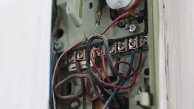 Evdeki eski bir güvenlik sistemine yakın çekim. Hatalı kablolar ve tozlu bir cep telefonu ile dahili iletişim kutusunu aç. Eski model güvenlik sistemi evin içinde, ev içi koruma sağlıyor.