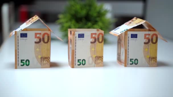 Miniatur-Hausmodelle aus Euro-Banknoten auf dem Tisch, handbemalte Baurahmen mit Papierdach. Ersparnisse und Investitionen in Immobilien, Finanztransaktionen beim Kauf neuer — Stockvideo