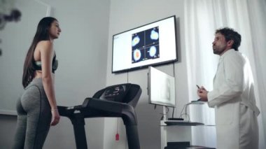 Ortopedi uzmanının uzmanlık alanı. Düz taban sorunu olan kadın hasta. Doktorun ayak taraması yaparken özel teşhis koşu bandında kalıyor.