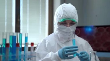 Kimyasal çözeltilerle yapılan laboratuvar deneyleri, koruyucu giysili kadın araştırmacılar steril test tüpleri ve farklı kimyasal bileşiklerle çalışıyorlar. Laboratuvar araştırmaları, aşı geliştirme...
