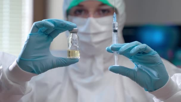 Naukowiec w dziedzinie osłony ochronnej trzymający fiolkę z roztworem i strzykawką w rękach, profesjonalny wirusolog pracujący z wirusami i opracowujący szczepionkę przeciwko wirusowi covid-19. Szczepienie ludzi — Wideo stockowe