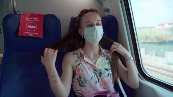 Vrouw die hard ademt per trein met beschermend medisch masker tijdens een coronavirus pandemie, vermoeide vrouw die handen schudt voor het gezicht om het bewustzijn niet te verliezen. vrouw zit alleen in de trein volgende — Stockvideo