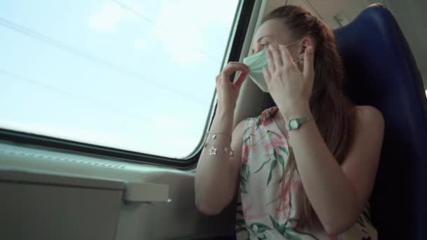 Vrouw met een medisch masker voelt zich slecht rijden met de trein, vrouw gaat het bewustzijn te verliezen als gevolg van het gezicht masker en harde ademhaling, vrouw schudden handen in de voorkant van het gezicht, terwijl het kijken uit het raam. Sociale zaken — Stockvideo