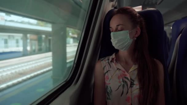 Mujer con máscara médica protectora durmiendo en tren y despertando al llegar a la estación. Medidas cautelares en transporte público y lugares, prevención de la infección por coronavirus y propagación en — Vídeos de Stock