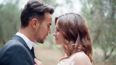 Genç evli çiftin samimi ve romantik duyguları. Yakışıklı koca, güzel karısını öperken bir kadın ona sarılıyor. Vücutlardaki şefkat ve şefkat jestler, insanlar arasındaki sevgi