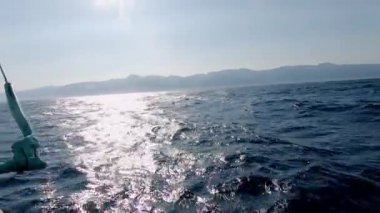 Uçurtma sörfü acemisi gün batımında suda sörf yapıyor, adam tropik yaz yerinde ekstrem spor eğitimi alıyor. Su yüzeyi ve yaz gevşemesi üzerinde çalışma