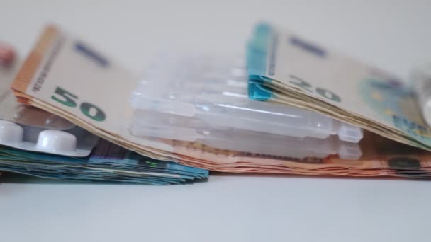 Diferentes medicamentos misturados com a moeda de papel do euro em fundo branco, pílulas caras no mercado farmacêutico, aumentando os preços dos medicamentos. Prescrição de remédio de alto custo, cuidados de saúde — Vídeo de Stock