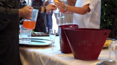 Düğün partisinde konuklara servis yapan restoran garsonu, büfenin önünde duran bardaklara meyve suyu ya da kokteyl dolduran hizmetçi. Aperatifler ve atıştırmalıklar. Yemek ziyafeti.