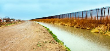 US border fence to Mexico at El Paso clipart
