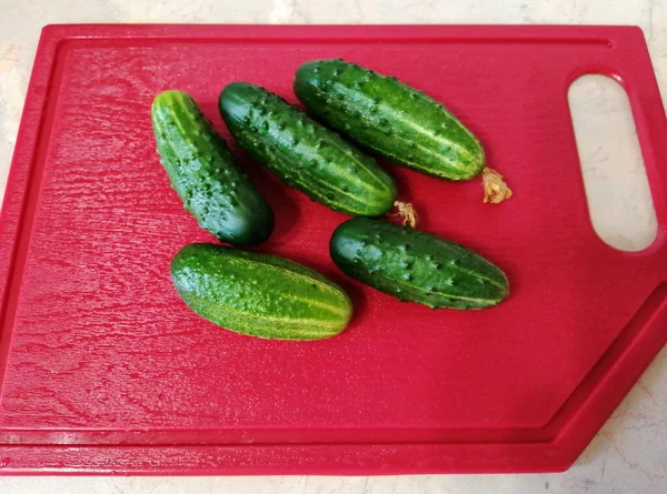 Kırmızı Kesme Tahtasındaki Yeşil Olgun Salatalıklar Fotoğraf Yakın Plan Yukarıdan — Stok fotoğraf