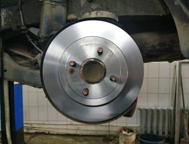 Benzin istasyonunda bir yolcu aracının arka fren disklerini değiştirmek. Yakın plan fotoğraf. Makro fotoğrafçılık.