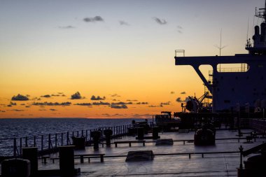 Süper tanker günbatımı arka plan üzerinde konaklama bloğunu silüeti