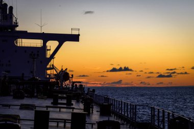 Süper tanker günbatımı arka plan üzerinde konaklama bloğunu silüeti