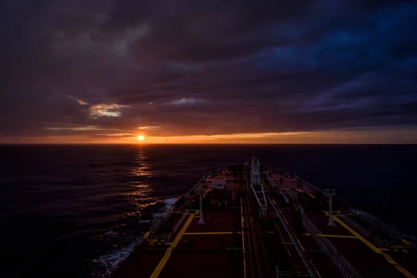 Sunset view from navigation bridge window of super tanker
