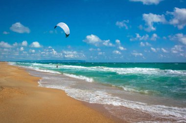 Güneşli kum plaj ve mavi bulutlu gökyüzü