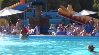 Şehir parkında büyük bir yüzme havuzu. İnsanlar sıcak bir günde banyo yapar ve güneşlenir..