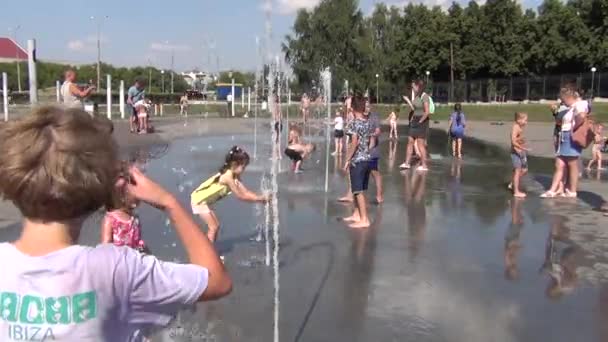 城市居民和城市公园里的孩子们享受来自喷泉的水 — 图库视频影像