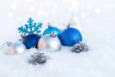 Bir açıklıkta, karda yatan Noel süsleri..