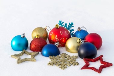 Çok renkli Noel süsleri kar üzerinde yalan.