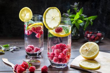 Ahududu, limon ve nane karanlık bir arka plan üzerinde serinletici içecek.