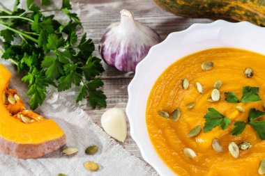 Ahşap bir zemin üzerine maydanoz ile kabak çorbası.