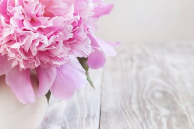 Ahşap bir masada pembe şakayık demeti. Hediye Sevgililer Günü.